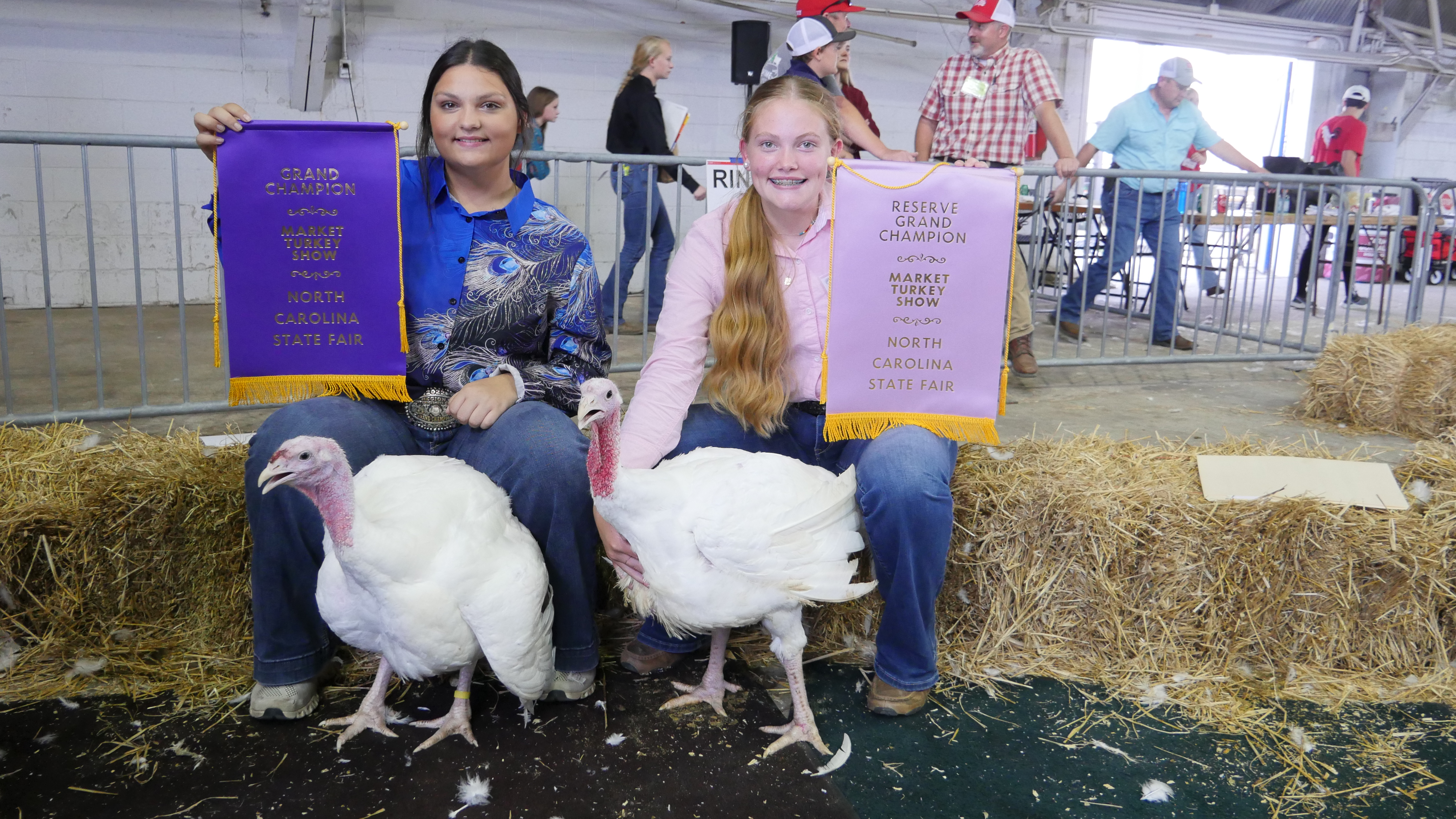 Two girls pose with prize winning Market turkeys at the Market Turkey Show.